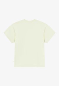 T-shirt jaune clair à manches courtes, encolure ronde, fabriqué en coton doux, avec une petite étiquette cousue en bas à gauche. Texture lisse.