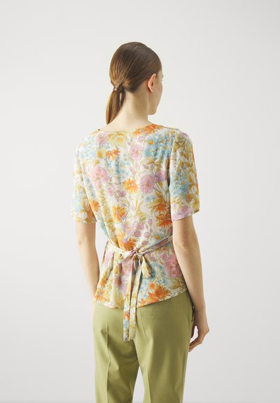 Mehrfarbige Bluse mit kurzen Ärmeln und gebundenem Taillengürtel. Der Stoff hat eine weiche Textur mit einem lebhaften Muster verschiedener Blumen.