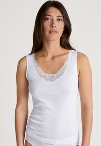 Witte tanktop met kantafwerking bij de halslijn, gemaakt van zachte katoen, met een aansluitend ontwerp en zonder mouwen.