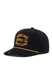 Schwarze Cordmütze mit gebogenem Schirm, versehen mit gelb gesticktem "HERSCHEL SUPPLY CO." und "QUALITY GOODS" Text sowie einem gelben Akzentstreifen.
