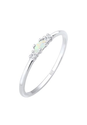 Bague en argent avec pierre centrale opale ovale flanquée de deux petites pierres précieuses rondes transparentes sur une fine bande estampillée 925.