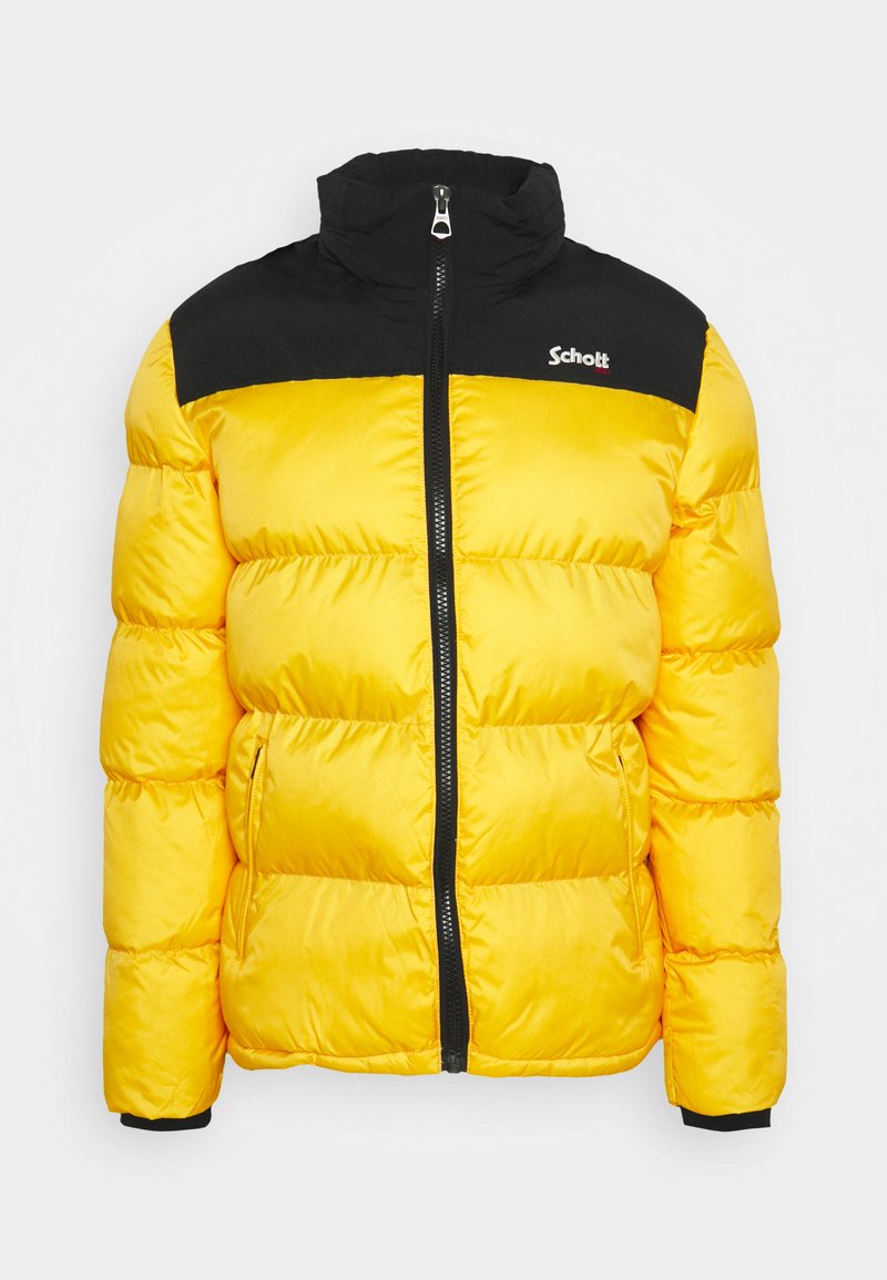 Doudoune jaune avec un panneau supérieur noir, fermeture éclair et poches latérales. Caractérisée par un tissu matelassé et un logo de marque sur la poitrine.