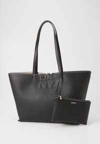 Black textured leather tote bag with dual handles and embossed DKNY logo. Includes a detachable black pouch with a zipper and logo accent.