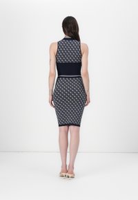 Abito in maglia caratterizzato da una silhouette aderente, colore blu navy con motivi geometrici bianchi, design senza maniche e orlo fino al ginocchio.