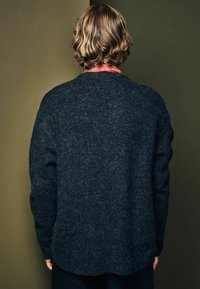 Dunkelgrauer Strickpullover mit einer weichen, strukturierten Oberfläche, Rundhalsausschnitt und gerippten Bündchen, von hinten betrachtet.