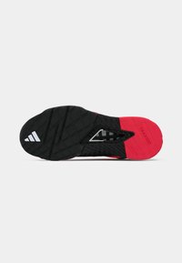 Black and red athletic shoe sole with textured grip pattern and a prominent white logo. Features a triangular cutout design.