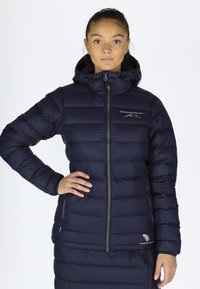 Navy puffer jacket with horizontal quilting, a zippered front, and an adjustable hood. Features a logo on the left chest and side pockets.