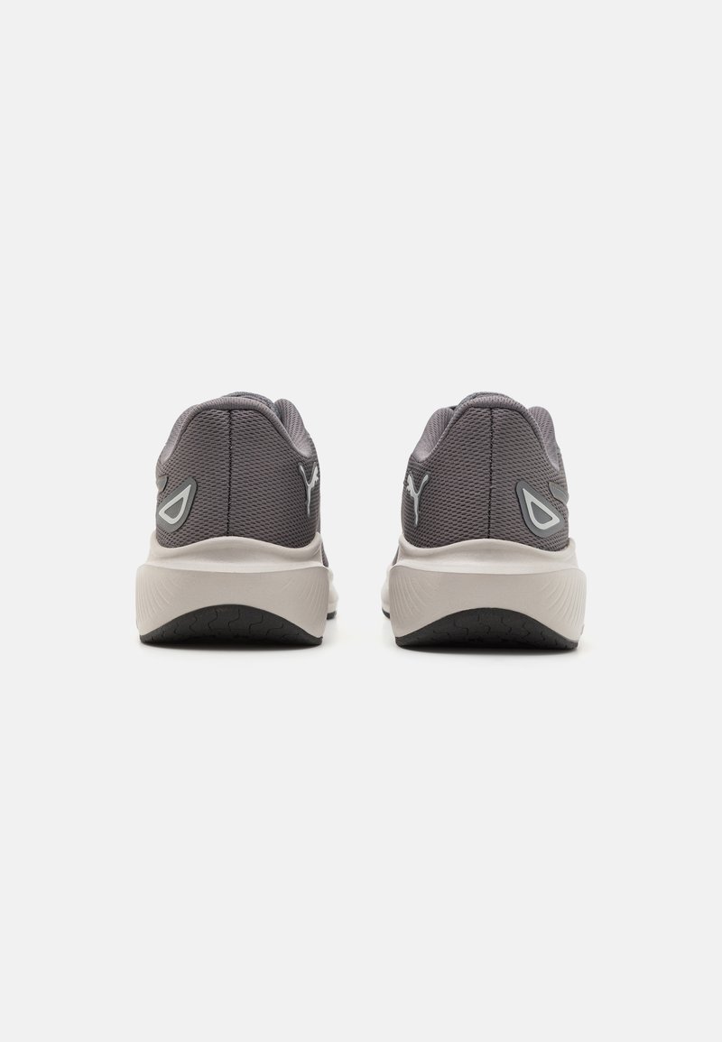 Zapatillas deportivas grises con partes superiores de malla y cuellos acolchados. Presenta una media suela blanca y suelas exteriores de goma negra texturizada. Detalle del logo notable en los laterales.