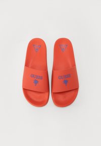 Chanclas de goma rojas con superficie texturizada, que presentan un logo azul y un gráfico de palma en la correa. Diseñadas para uso casual.