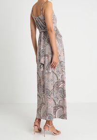 Maxi-jurk met paisleypatroon in tinten van roze en grijs. Heeft dunne bandjes, een aansluitend lijfje en vloeiende stof met een cinched taille.