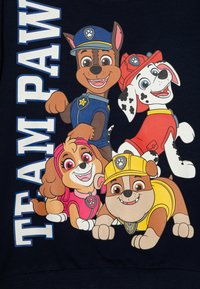 Felpa blu navy con cani cartoon di vari colori, tra cui marrone, rosa e maculato, con il testo "TEAM PAW" a sinistra.
