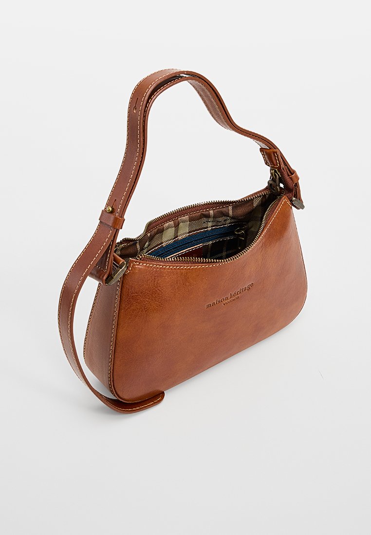 Braune Leder-Schultertasche mit verstellbarem Riemen, Reißverschlussverschluss und gefüttertem Innenfutter aus gemustertem Stoff.