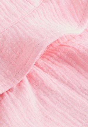 Lyserødt stof med en krøllet tekstur, der har rynket detalje og synlige syninger.