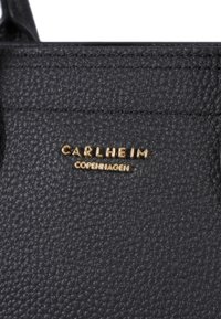 Borsa in pelle nera con texture, caratterizzata da un logo del marchio in rilievo dorato "CARLHEIM COPENHAGEN" sul davanti. Dettagli di cucitura liscia visibili.
