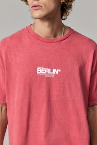 Camiseta de manga corta y cuello redondo en tejido rojo desgastado, con texto impreso en blanco: "NÚMERO 01 BERLÍN POTSDAMER 2009" en el pecho.