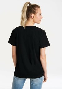 Black cotton t-shirt with short sleeves and a round neckline, viewed from the back. Smooth texture, standard fit, and no visible patterns.