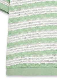 Lysegrøn og hvid stribet strikket stof med åbent blonde mønster og ensfarvet grøn ribbesøm forneden og ved ærmekanten.