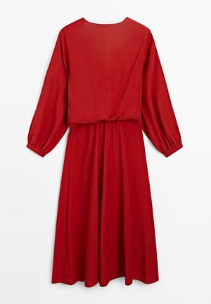 Rode jurk met lange mouwen, taille-naad en een ontspannen silhouet. Gemaakt van een soepele stof met een zachte textuur.