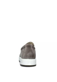 Scarpe slip-on in suede grigio con suola bianca a profilo basso e punta arrotondata. Il tacco è leggermente imbottito per il comfort, con dettagli di cuciture minimi.