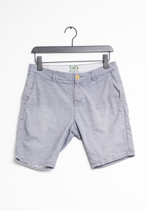 Shorts gris clair fabriqués dans un tissu doux, dotés d'un unique bouton jaune, de poches avant et d'un bas ourlé avec un petit pli.