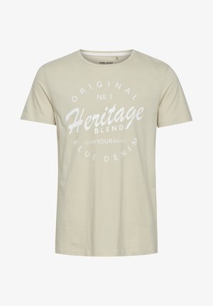 Beige katoenen t-shirt met ronde hals. Beschikt over een grote witte grafische print met de tekst "Heritage Blend" en aanvullende tekst, korte mouwen.