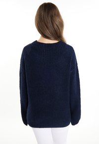 Maglione in navy blue lavorato a maglia con texture a coste, collezione rotondo e spalle scese; vestibilità rilassata, adatto da indossare sopra abbigliamento leggero.