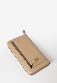 Portafoglio in pelle beige con una tasca con zip. Presenta una texture liscia e una zip nera a contrasto con un dettaglio a chiusura a scatto.