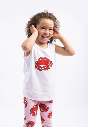 Weißes ärmelloses Tanktop mit einem Grafikdruck eines roten Krebses, kombiniert mit rosa Leggings, die mit einem sich wiederholenden roten Krebs-Muster verziert sind.