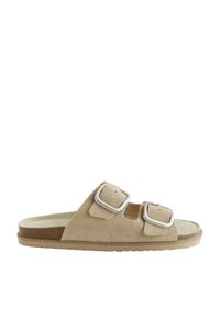 Sandale beige en daim à bout ouvert avec deux boucles argentées réglables et une semelle plate en caoutchouc.