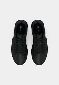 Črni športni copati z gladkim usnjenim zgornjim delom, zaobljenim prstom in ravnimi vezalkami. Imajo oblazinjen ovratnik in minimalističen dizajn. Na notranji podplati je znamka.