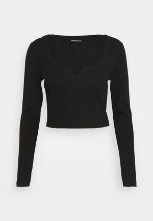 Schwarzes, langärmeliges, bauchfreies Top mit wellenförmigem Ausschnitt. Hergestellt aus glattem Stoff, mit figurbetontem Schnitt und minimalen Akzenten.