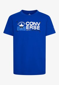 Camiseta de algodón azul con mangas cortas. Presenta un gran texto de marca en blanco y negro y un gráfico de estrella. Diseño de cuello redondo.