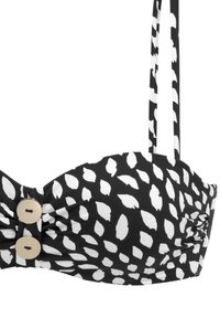 Zwart-witte bikini top met een bladerenpatroon, voorzien van een gedraaide voorkant en twee beige knopen als accent. Verstelbare bandjes.