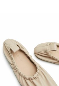 Bežinės odinės butai su susiraukšlėjimu, apvalia nosimi ir elastine anga. Vidus pasižymi lygiu, lengvu tekstūru.