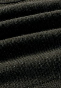 Primo piano di un tessuto a maglia ribbed marrone scuro che mostra la trama e strati morbidi e piegati.