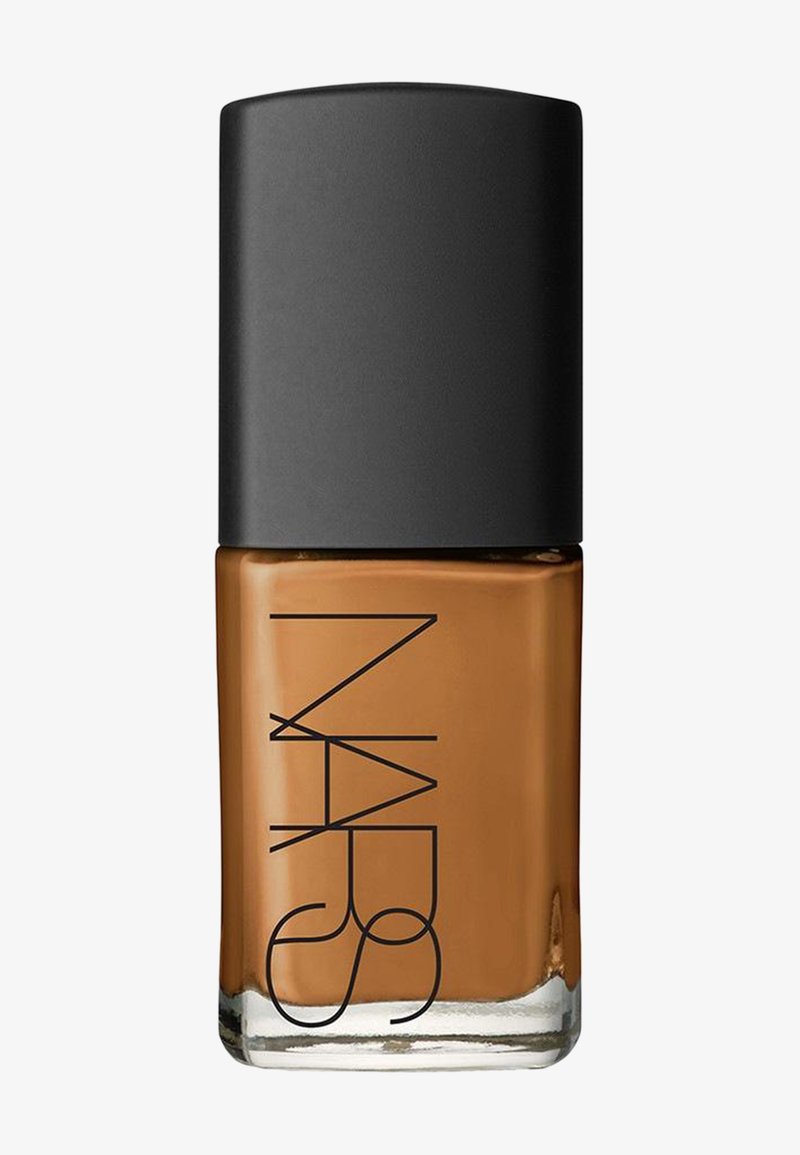 NARS neglelakk i en rektangulær glassflaske med svart lokk. Fargen er en varm brun med en blank overflate.