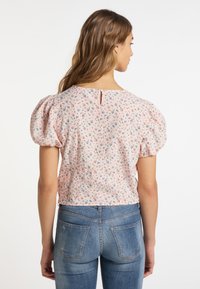 Blomsterbluse i blød pink stof med puffede ærmer, lukning med knapper bagpå og små flerfarvede blomsterprints. Tætsiddende design, cropped længde.