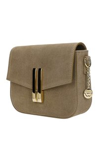 Kleine rechthoekige taupekleurige suède handtas met een gouden verticale sluiting en een gouden kettinghanger aan de zijkant.