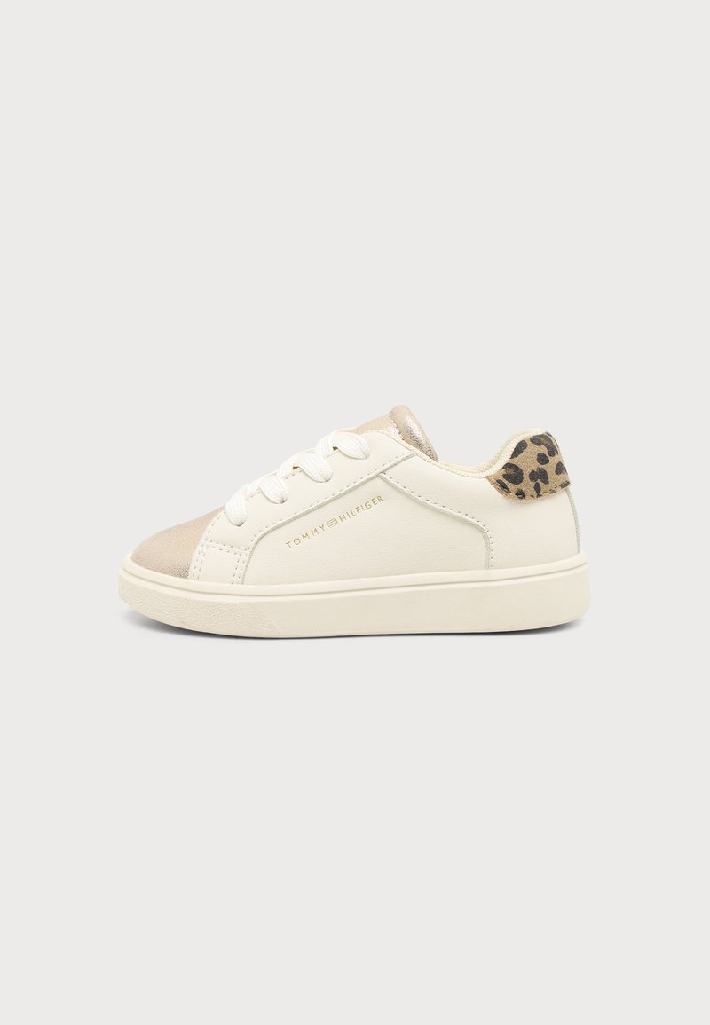 Λευκό sneaker χαμηλής γραμμής με μπεζ μύτη, ταμπέλα με σχέδιο λεοπάρδαλη στη φτέρνα, λευκά κορδόνια και λογότυπο Tommy Hilfiger στο πλάι.