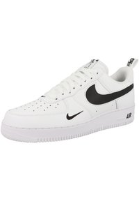 Sneaker bianca in pelle con logo swoosh nero, punta rotonda, tomaia perforata per ventilazione, lacci piatti e colletto imbottito. La suola presenta un battistrada testurizzato.