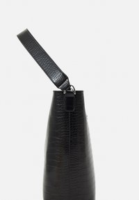 Sac en cuir noir à motif crocodile avec une forme effilée, doté d'une fine sangle noire, de quincaillerie métallique et d'une texture lisse.