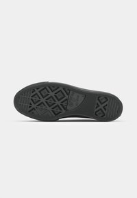 Semelle de sneaker en caoutchouc noir avec un motif de grip texturé composé de formes géométriques, logo de la marque et indication de taille.