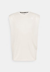 Jasno beżowy bezrękawnik sportowy wykonany z gładkiego materiału. Posiada okrągły dekolt oraz małe białe logo na górnej lewej części klatki piersiowej.