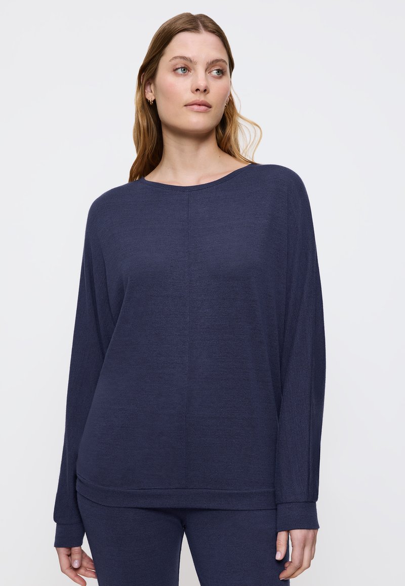 Top lungo a maniche con un blu navy, dal taglio morbido, scollato ampio e polsini a costine, realizzato in un tessuto leggero e texturizzato.