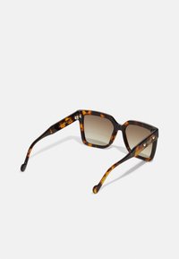 Ochelari de soare tortoise maro cu ramă pătrată, lentile cu gradient și detalii subtile cu logo pe braț. Finisaj texturat pe brațe.