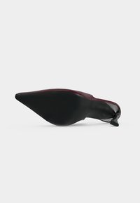 Chaussure à talon haut bordeaux unique vue de la semelle, avec un bout pointu et un talon stiletto fin sur un fond blanc uni.