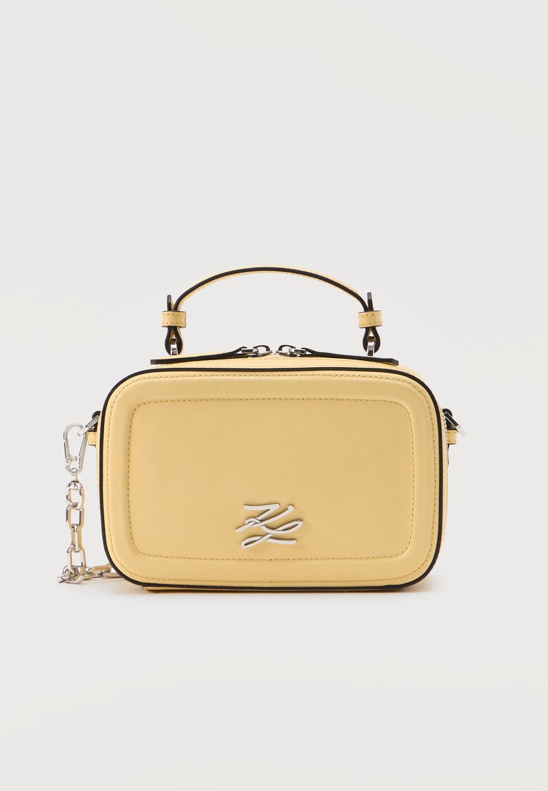 Sac à main rectangulaire doux de couleur jaune avec poignée courte, bandoulière chaîne argentée, double fermeture éclair et logo "KL" stylisé argenté sur le panneau avant.