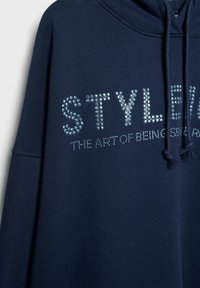 Sweat à capuche bleu marine avec cordons, avec les mots « STYLE » et « THE ART OF BEING » en petits strass sur la poitrine.