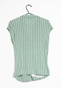 Haut vert à manches courtes avec un motif géométrique répétitif, fabriqué en tissu lisse. Présente un ourlet arrondi et une coupe décontractée.
