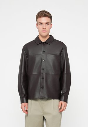 Sort læder skjortejakke med knaplukning foran, krave og lange ærmer. Har et paneldesign og en afslappet pasform.